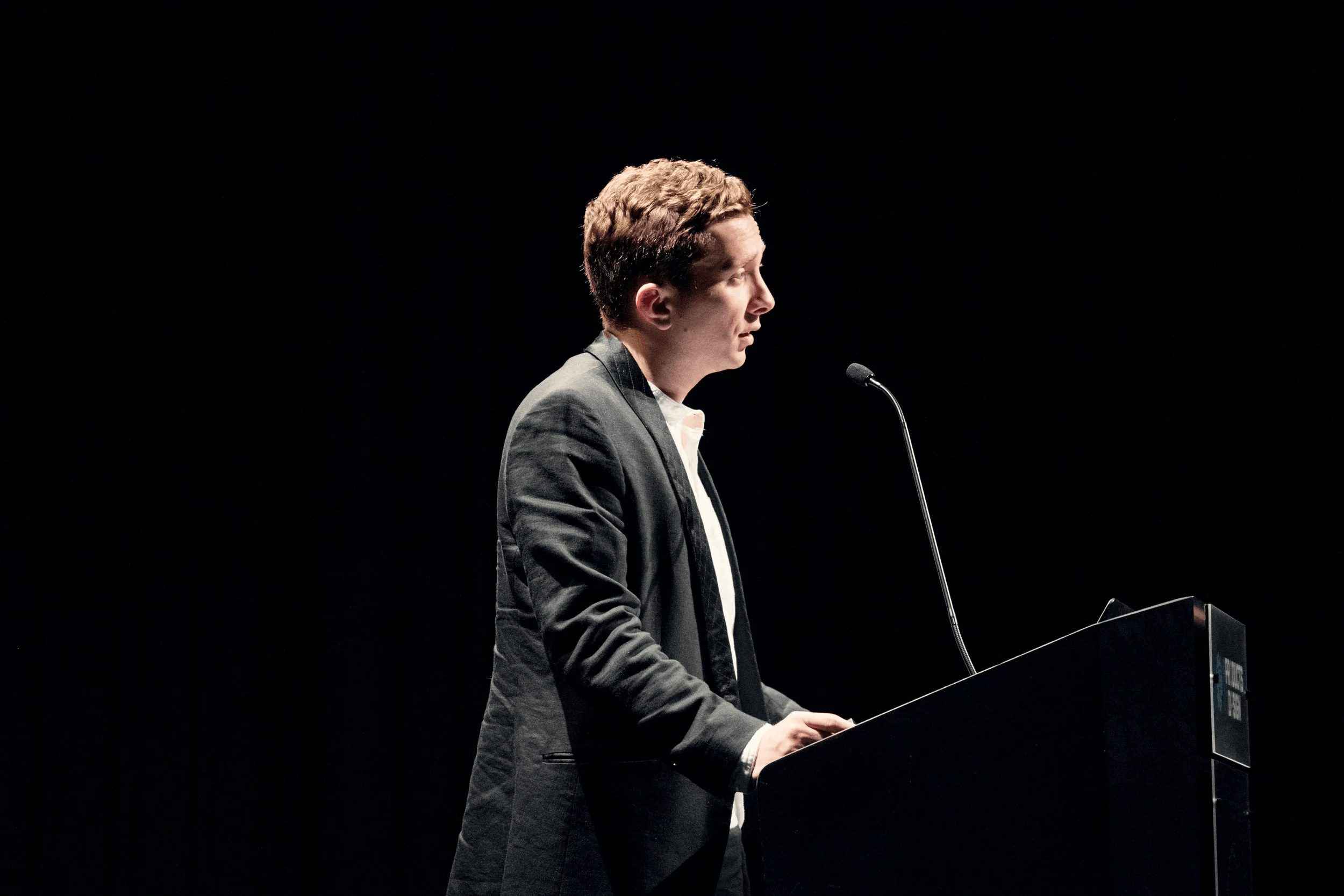 Will Crum presenting his master’s thesis at a podium